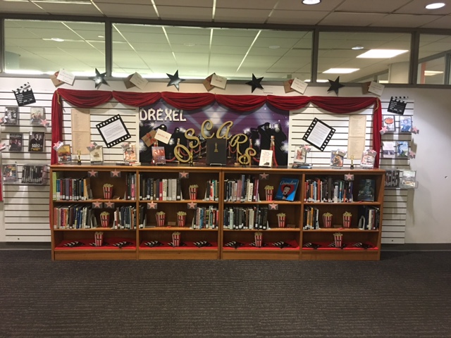 Bookshelves are filled with books and movies. All books and movies on display are past Oscar winners and nominees.